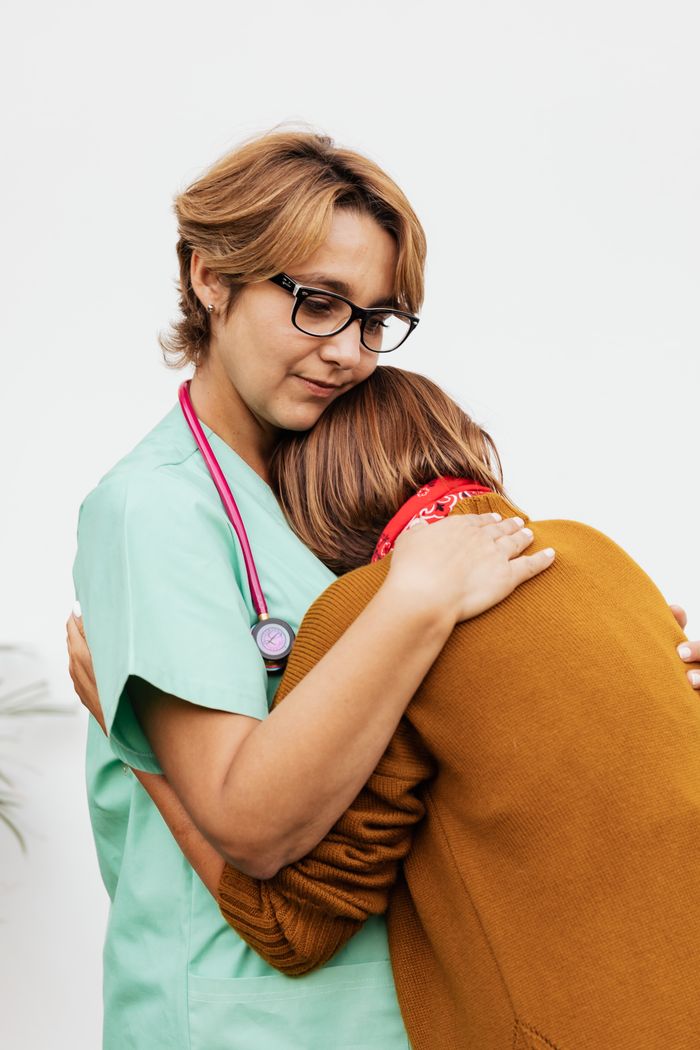 A compassionate nurse embracing a patient in a supportive hug.